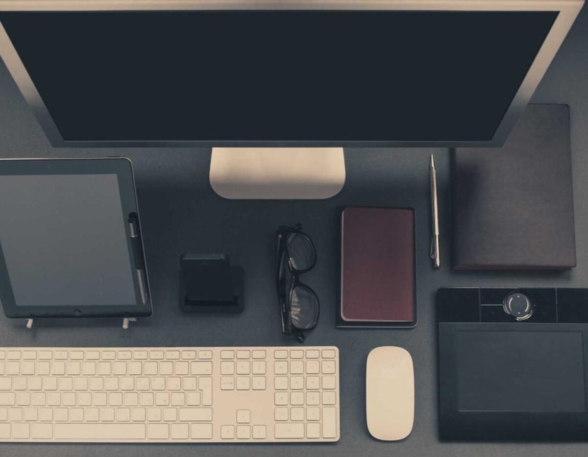 A desk with a monitor, tablet and keyboard